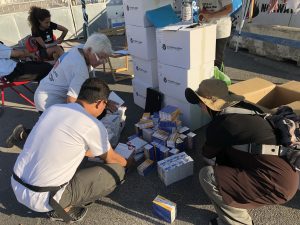 International and local volunteers inventory emergency medical supplies in the port of Naples.